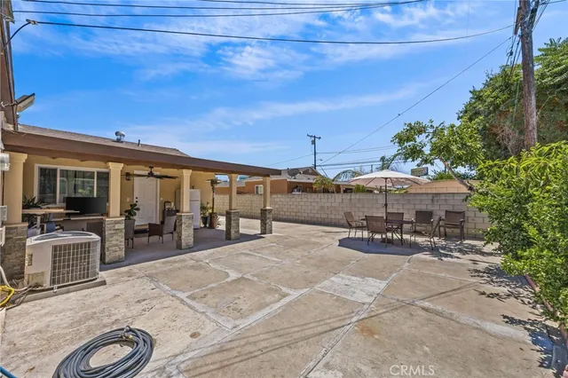 a view of a patio with table and chairs under an umbrella with wooden fence