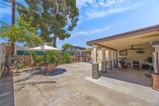 a view of a patio with a table and chairs under an umbrella
