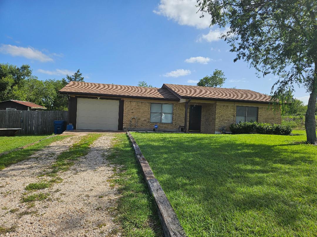 101 Brown Street Elgin, TX 78621 - Photo 2 of 33 A well-maintained lawn welcomes you to this single-story brick home with an attached garage.