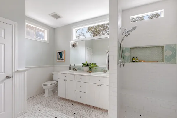 a bathroom with a sink a toilet and a mirror