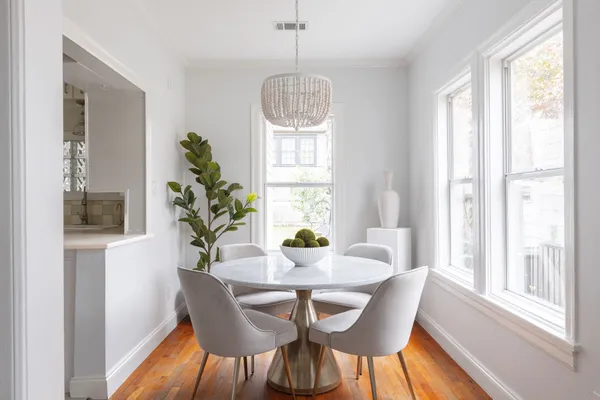 a dining room with furniture potted plants and wooden floor