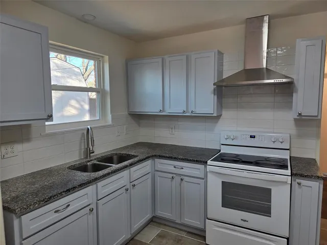 a kitchen with granite countertop white cabinets and white appliances
