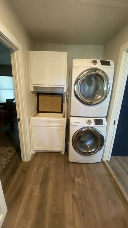 1202 Nix Road Lampasas, TX 76550 - Photo 19 of 20 Laundry room with cabinet space, stacked washing machine and dryer, and dark wood finished floors