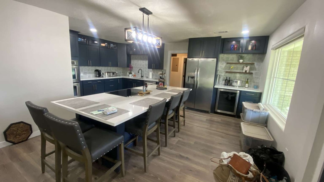 1202 Nix Road Lampasas, TX 76550 - Photo 3 of 20 Kitchen featuring a breakfast bar area, glass insert cabinets, decorative backsplash, and stainless steel appliances