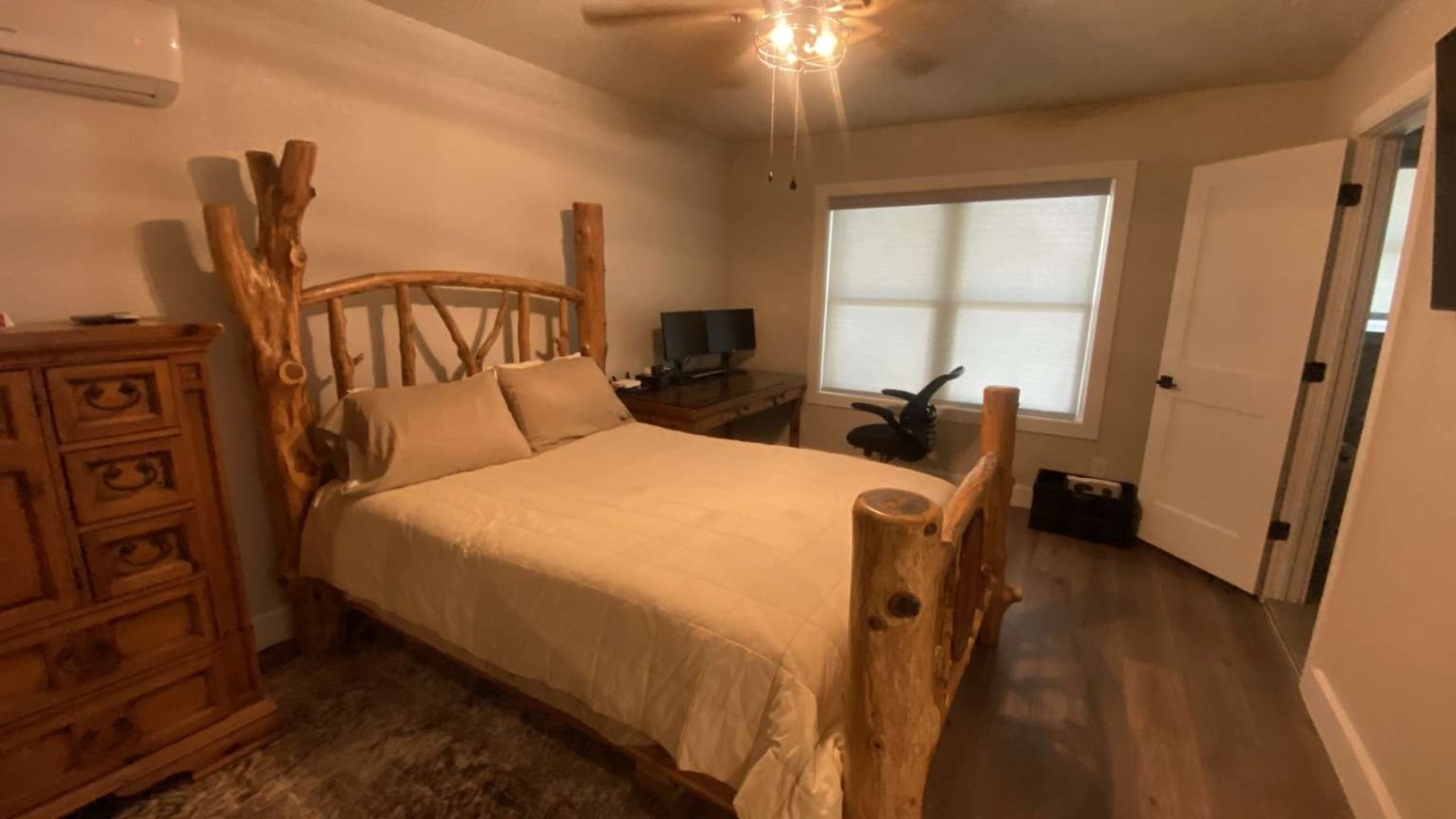 1202 Nix Road Lampasas, TX 76550 - Photo 7 of 20 Bedroom with a wall mounted AC, dark wood-type flooring, and a ceiling fan