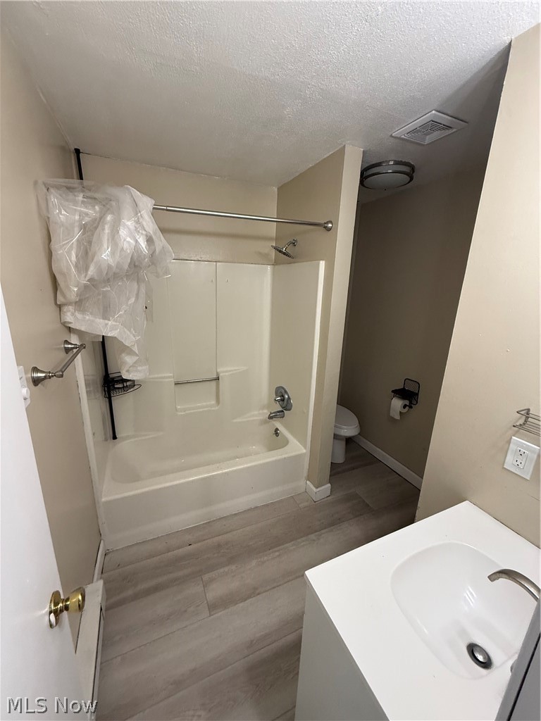 662 Sumner Street Akron, OH 44311 - Photo 8 of 10 Full bath featuring vanity, light wood-type flooring, shower combination, and a textured ceiling