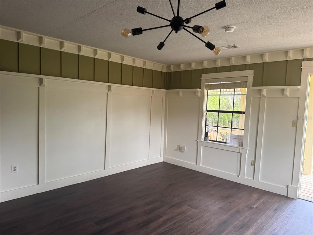 8330 Northeast 100th Avenue Bronson, FL 32621 - Photo 5 of 17 a view of an empty room with wooden floor and a window