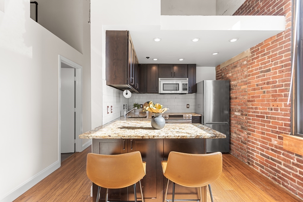 320 West 2nd Street, Unit 502 Boston, MA 02127 - Photo 7 of 21 a kitchen with a table chairs and a refrigerator