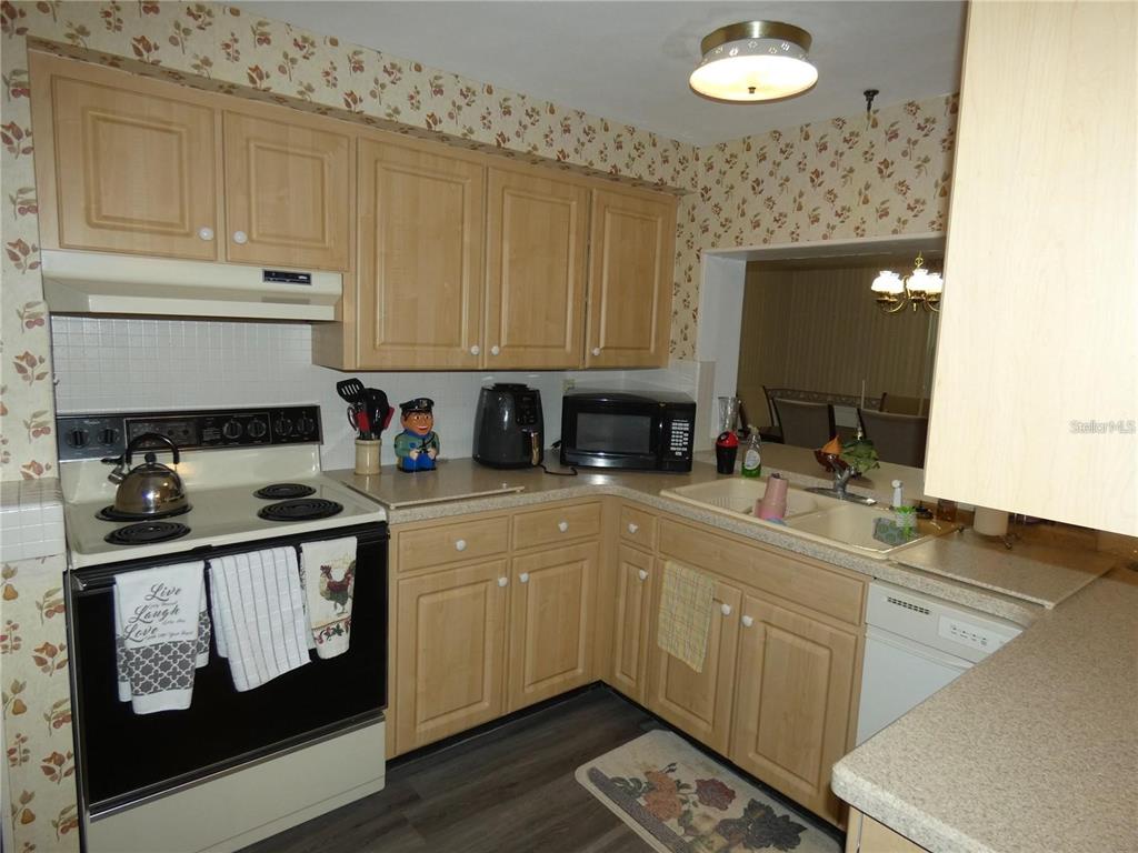 4392 Craftsbury Drive New Port Richey, FL 34652 - Photo 9 of 41 a kitchen with stainless steel appliances granite countertop a sink stove and cabinets