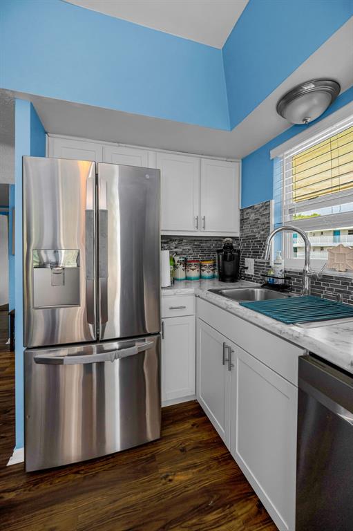 9945 47th Avenue North, Unit 210 St. Petersburg, FL 33708 - Photo 26 of 78 a kitchen with wooden floors appliances and window