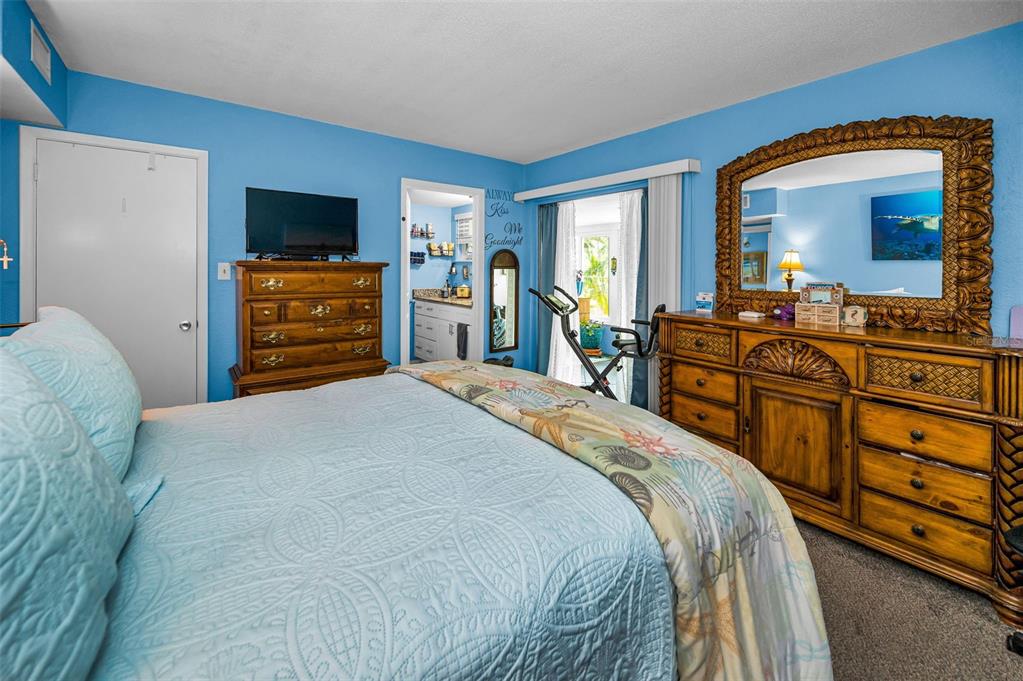 9945 47th Avenue North, Unit 210 St. Petersburg, FL 33708 - Photo 31 of 78 a bedroom with a bed and a flat screen tv