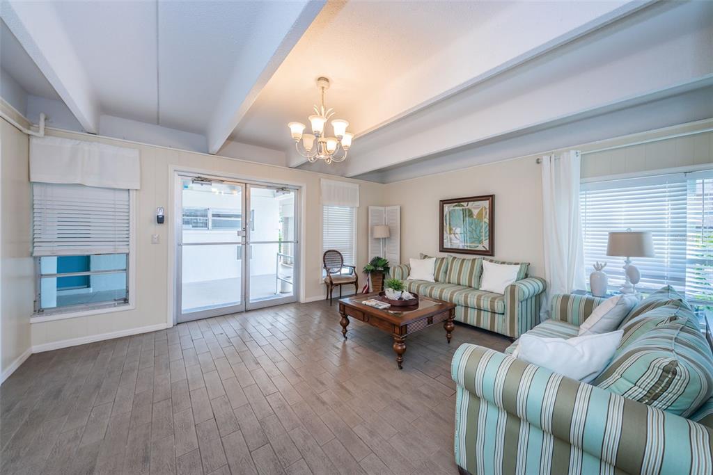 9945 47th Avenue North, Unit 210 St. Petersburg, FL 33708 - Photo 61 of 78 a living room with furniture and a chandelier