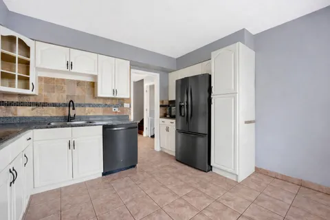 a kitchen with a refrigerator sink and cabinets