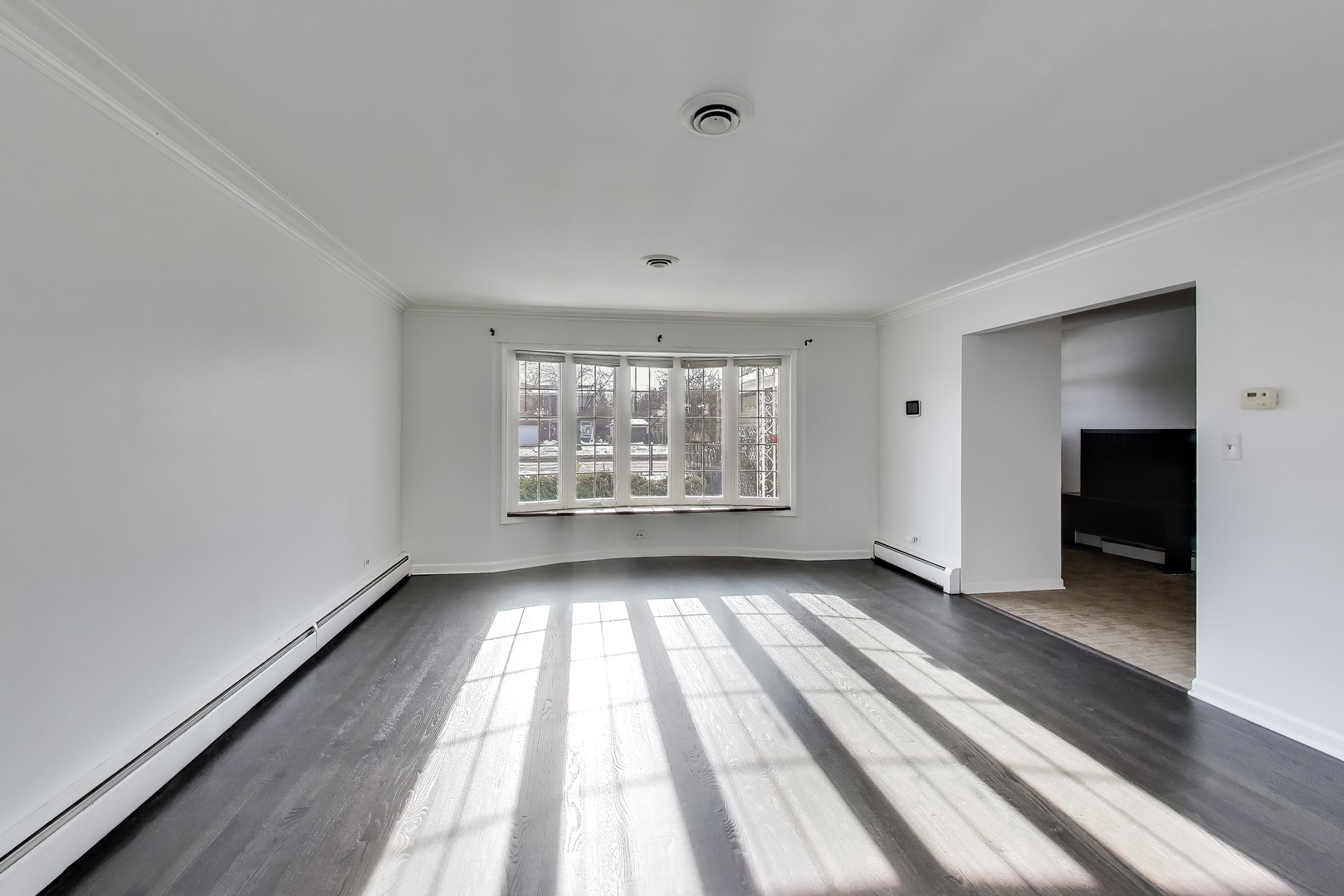 1006 Devon Avenue Park Ridge, IL 60068 - Photo 5 of 38 a view of an empty room with a window and wooden floor