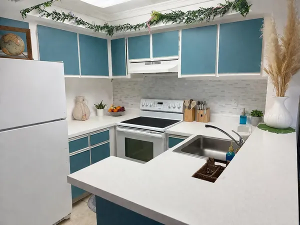 a kitchen with a refrigerator and a stove top oven
