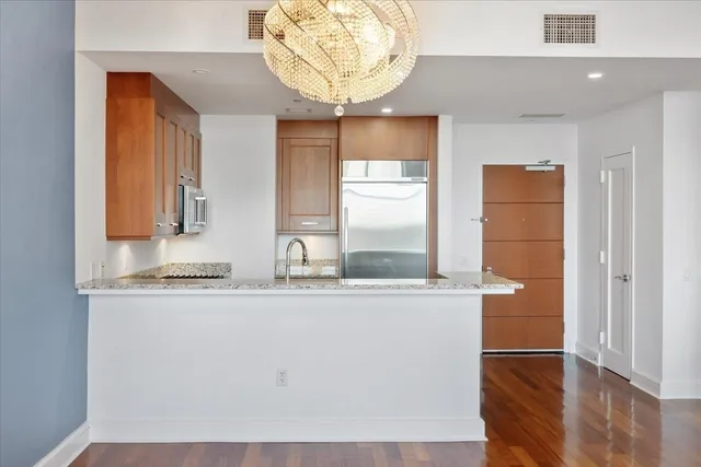 a kitchen with stainless steel appliances granite countertop a sink and a mirror