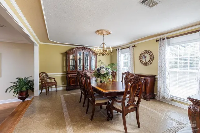 a view of a dining room with furniture and a chandelier