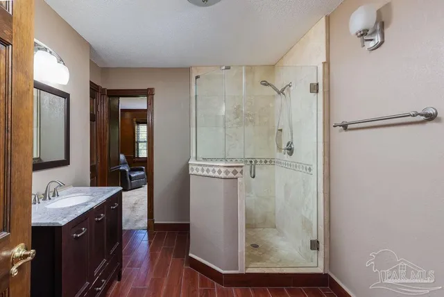 a bathroom with a granite countertop shower a sink and a mirror