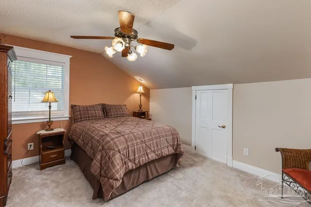 a spacious bedroom with a bed and a chandelier
