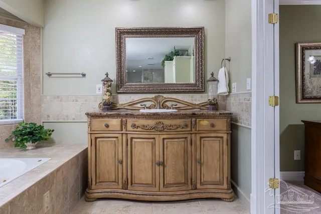 a large white kitchen with sink and cabinets