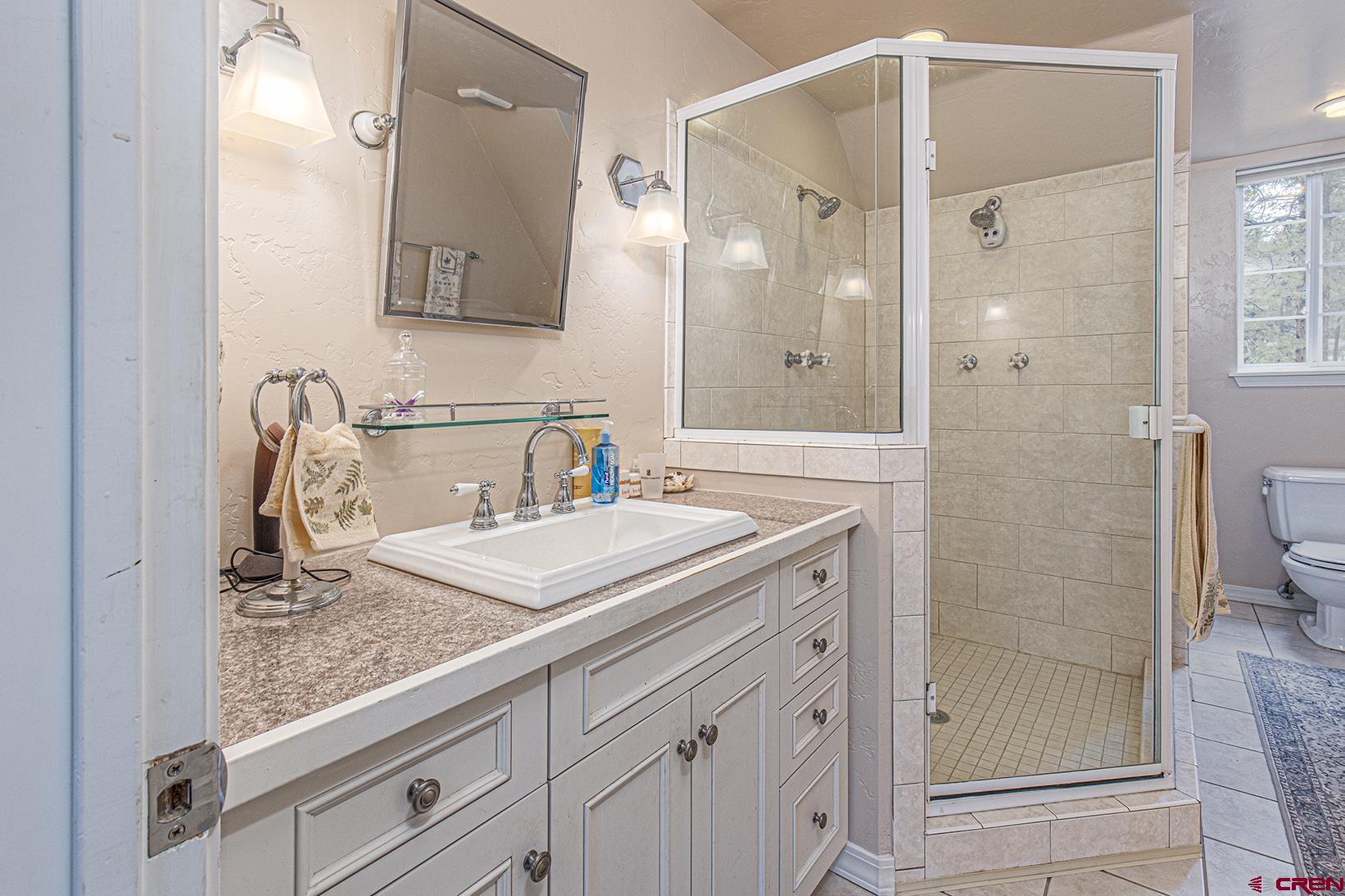 383 The Eagle Pass Durango, CO 81301 - Photo 17 of 37 a bathroom with a granite countertop sink a mirror and shower