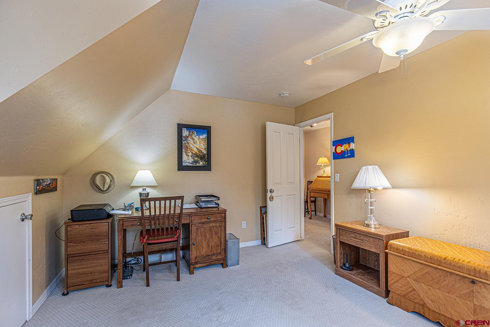 383 The Eagle Pass Durango, CO 81301 - Photo 22 of 37 a bedroom with furniture a desk and a chandelier
