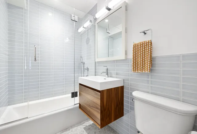 a bathroom with a sink a toilet and shower