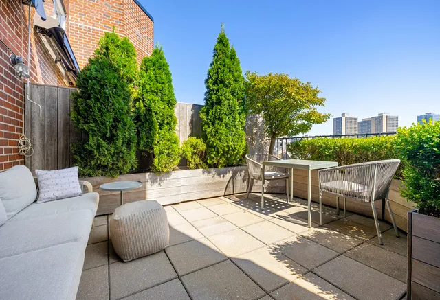 a view of a patio with a table and chairs and potted plants