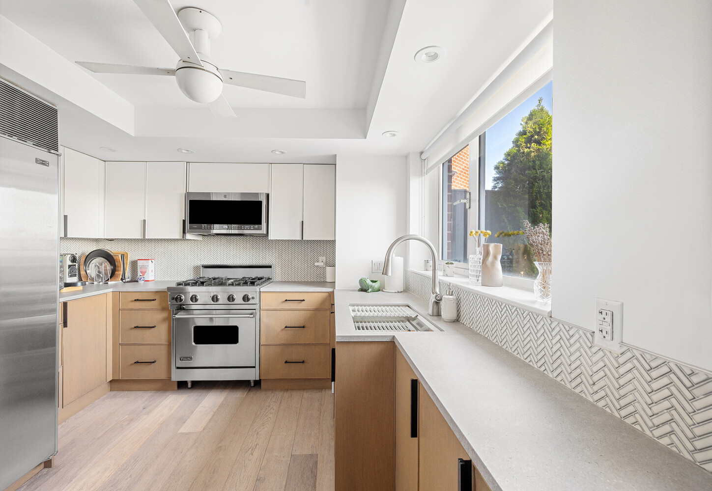 2 Charlton Street, Unit PH16F Manhattan, NY 10014 - Photo 7 of 20 a kitchen with stainless steel appliances granite countertop a stove a sink dishwasher and a refrigerator with wooden floor