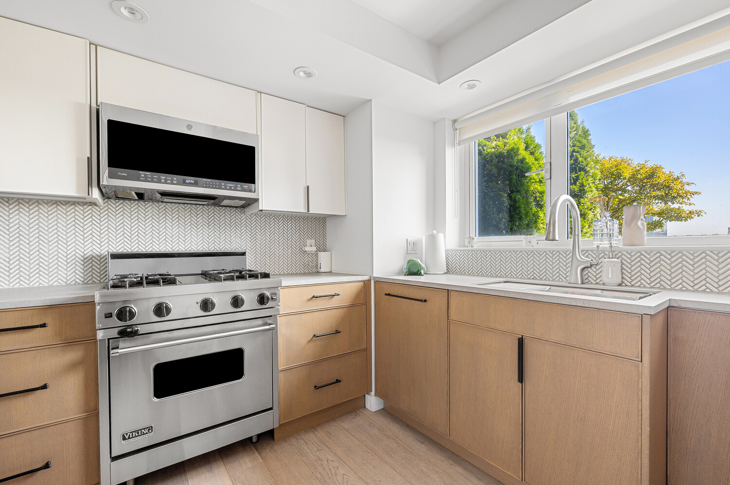 2 Charlton Street, Unit PH16F Manhattan, NY 10014 - Photo 8 of 20 a kitchen with stainless steel appliances white cabinets and a stove top oven