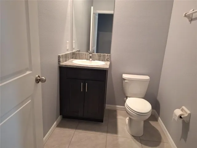 a bathroom with a granite countertop sink a mirror and tub