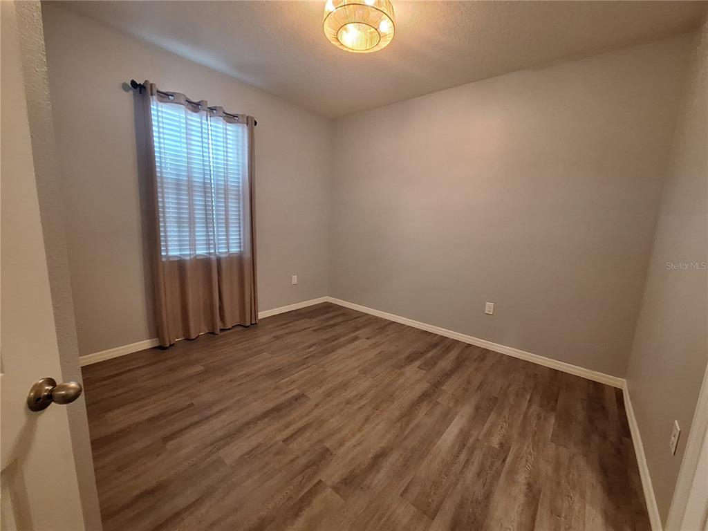 13483 Golden Lime Ave Spring Hill Spring Hill, FL 34609 - Photo 55 of 92 an empty room with wooden floor and windows