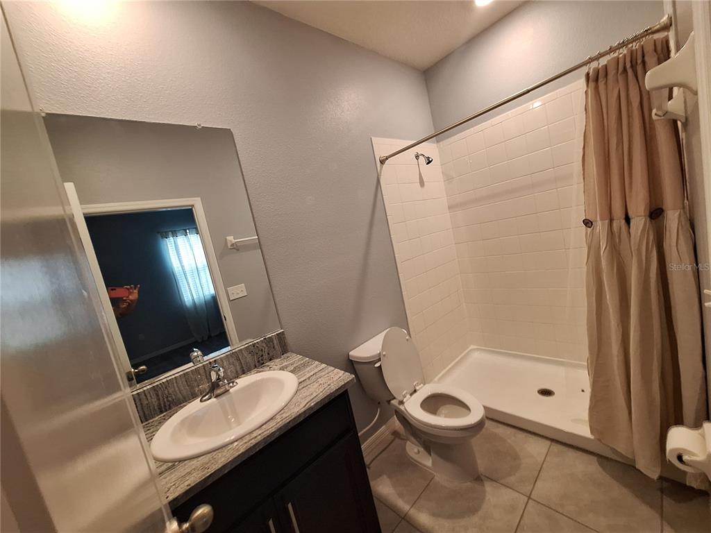 13483 Golden Lime Ave Spring Hill Spring Hill, FL 34609 - Photo 67 of 92 a bathroom with a granite countertop sink toilet a mirror and shower