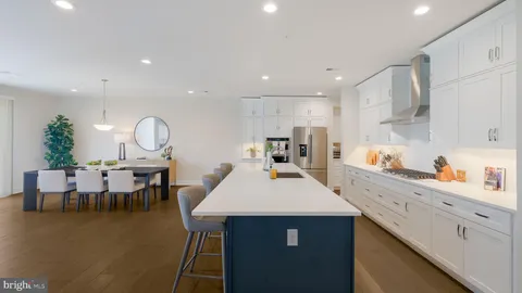 a large kitchen with kitchen island a dining table and chairs