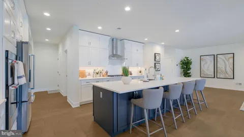 a kitchen with stainless steel appliances a dining table chairs and wooden floor
