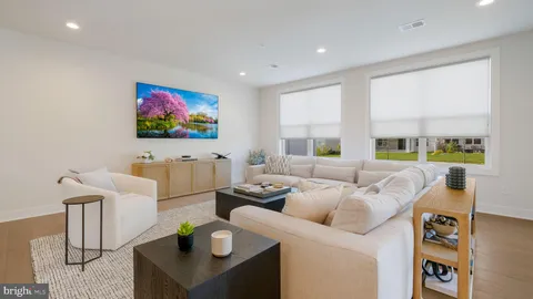 a living room with furniture a flat screen tv and a floor to ceiling window