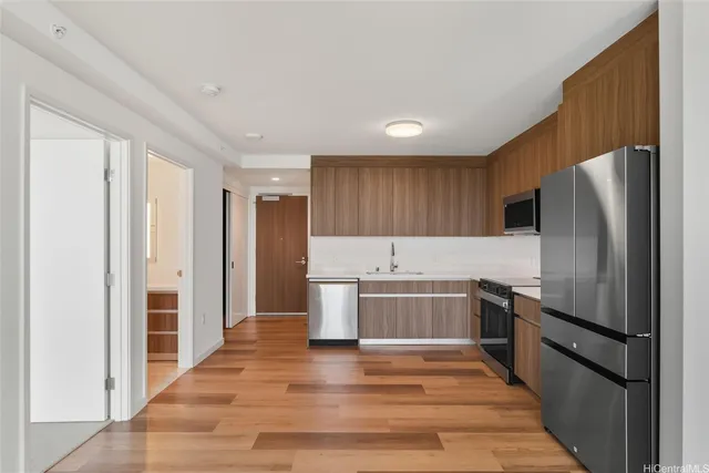 a kitchen with stainless steel appliances granite countertop a refrigerator and a stove top oven