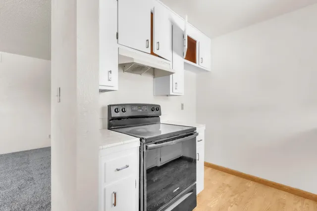 a kitchen with white cabinets and appliances