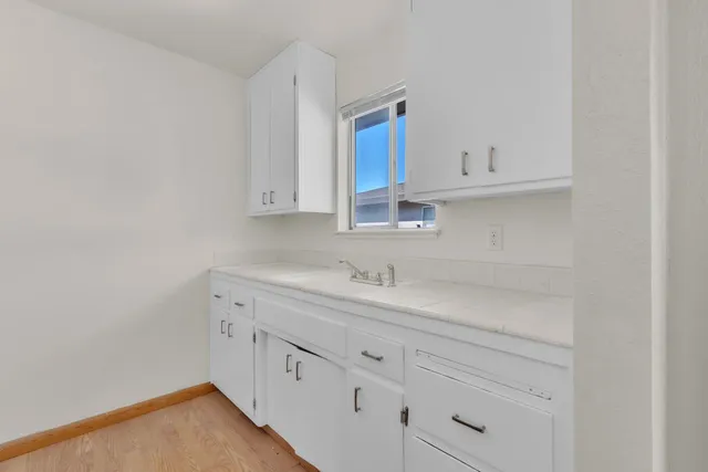 a kitchen with white cabinets appliances and a sink