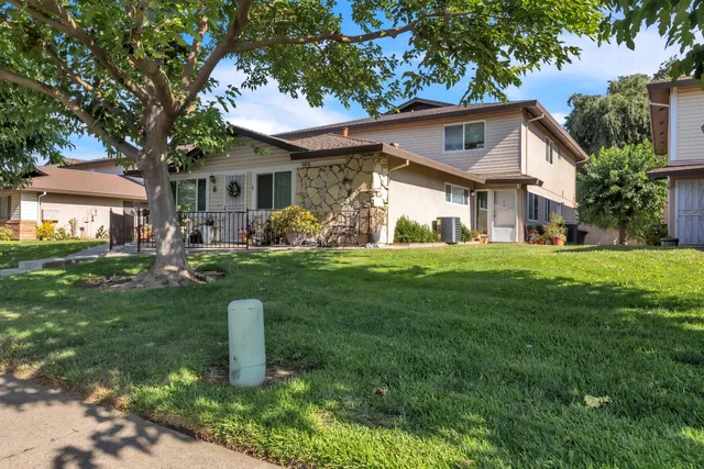 a front view of a house with a yard and trees