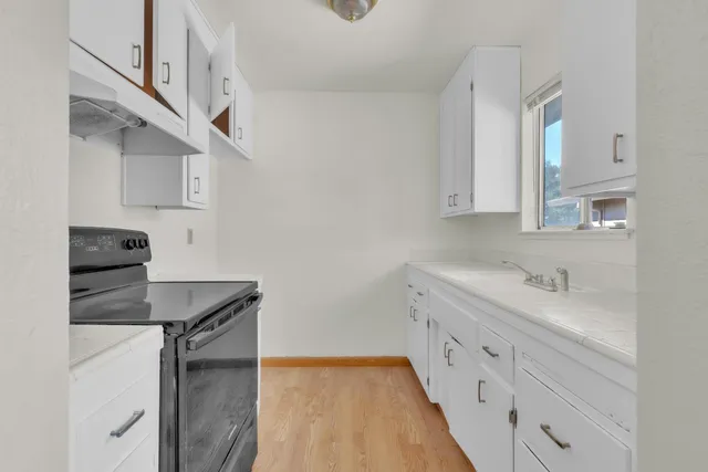 a kitchen with stainless steel appliances a sink stove and cabinets