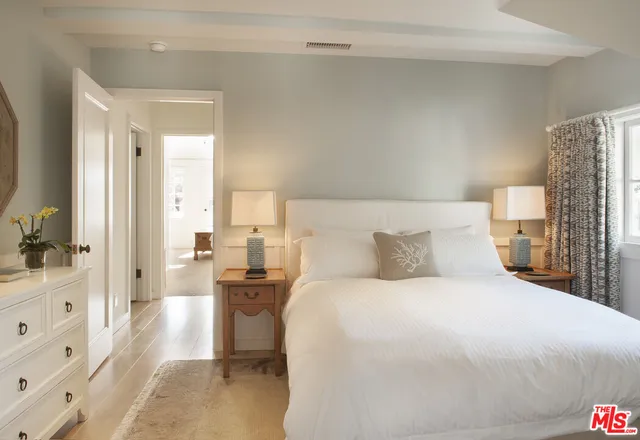 a bedroom with a bed and a view of living room