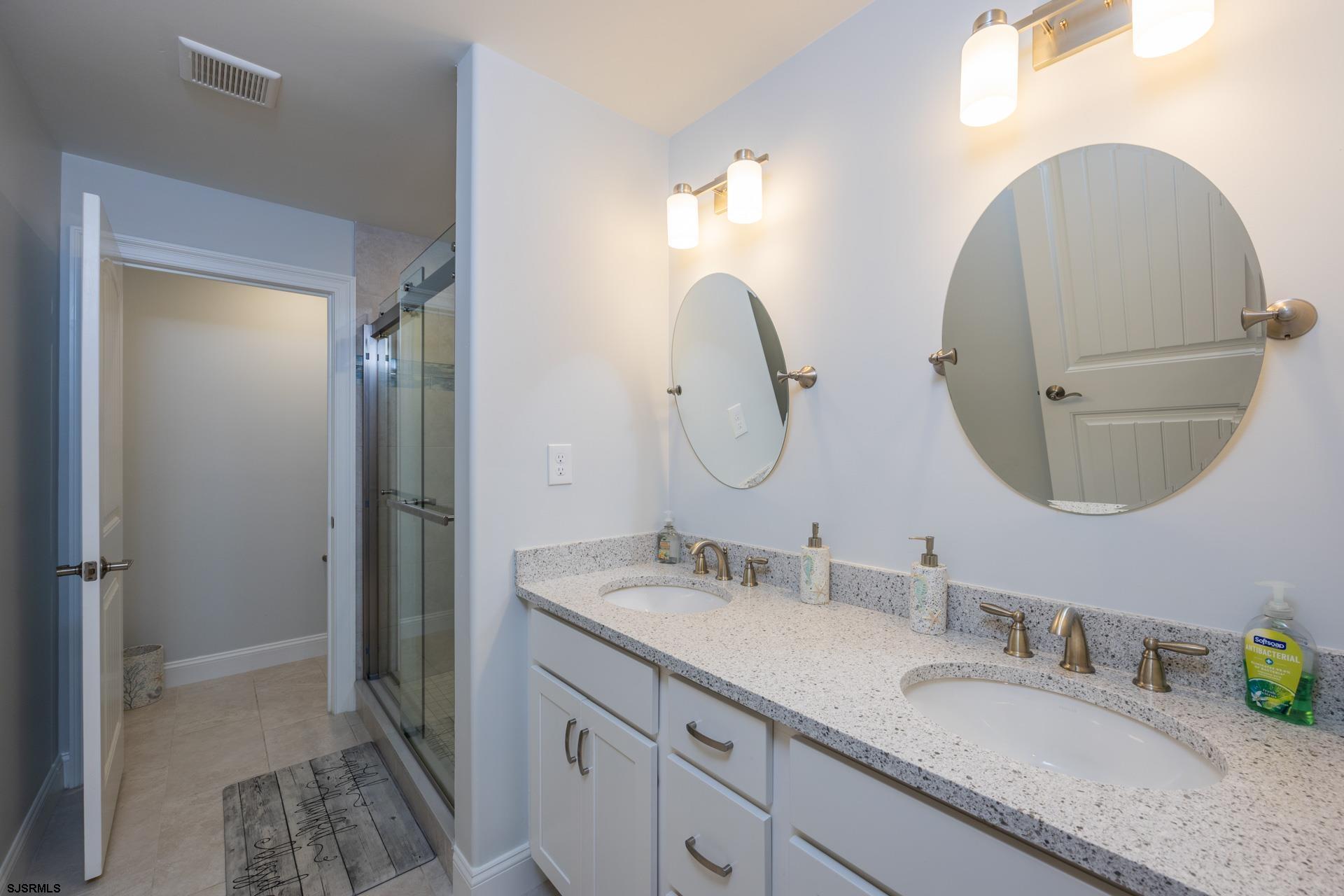 910 Ocean Avenue, Unit C Ocean City, NJ 08226 - Photo 16 of 36 a bathroom with a granite countertop double vanity sink and a mirror