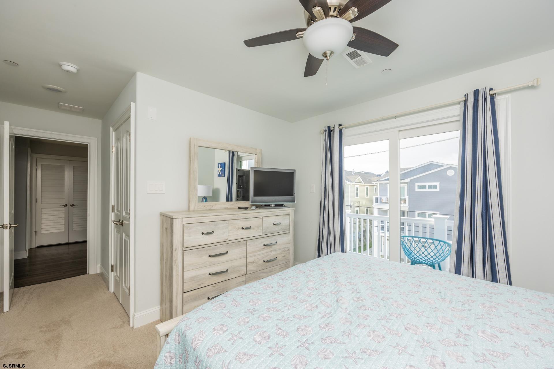 910 Ocean Avenue, Unit C Ocean City, NJ 08226 - Photo 22 of 36 a bedroom with a bed and a flat tv screen on dresser
