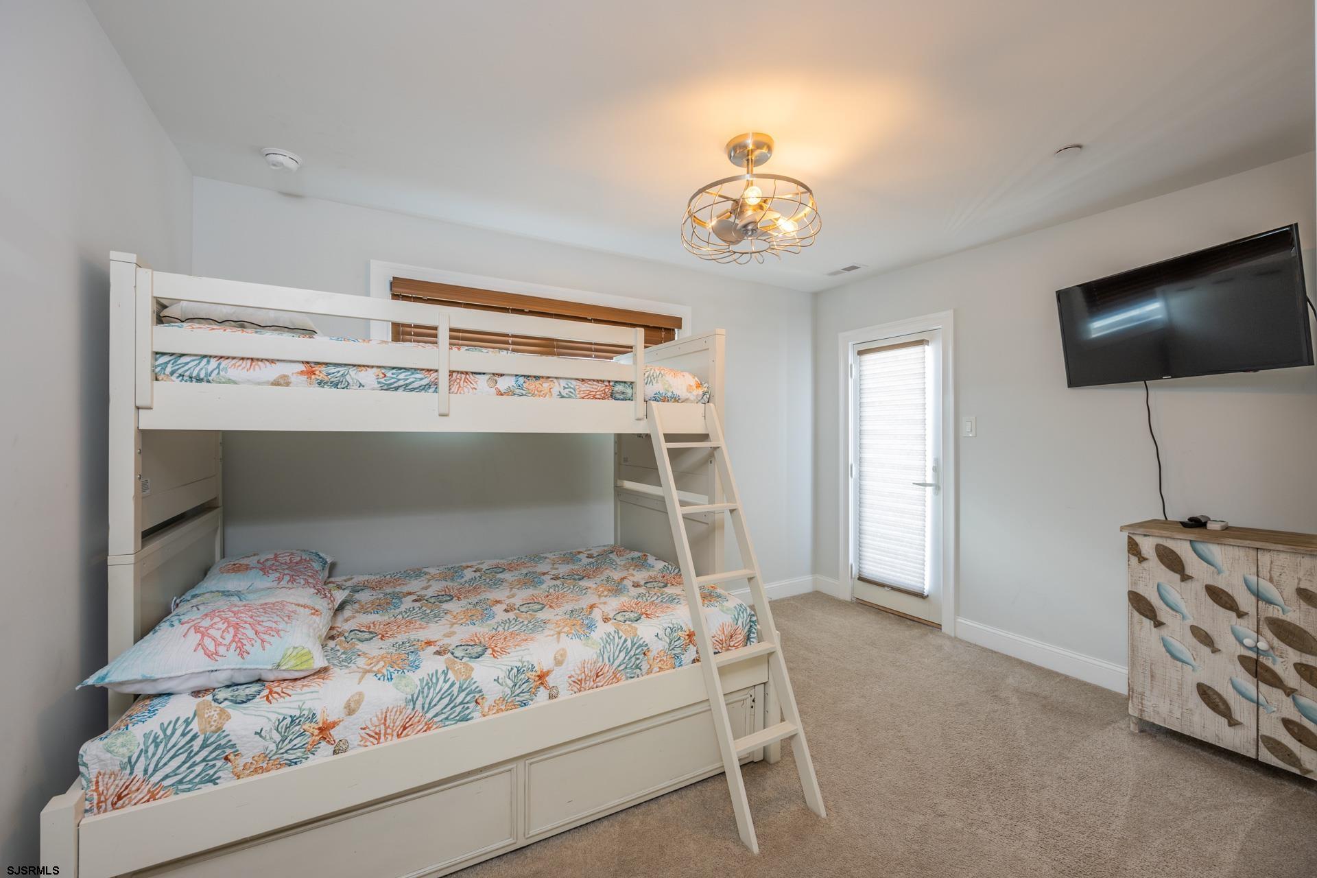 910 Ocean Avenue, Unit C Ocean City, NJ 08226 - Photo 25 of 36 a bedroom with a bed and a flat screen tv