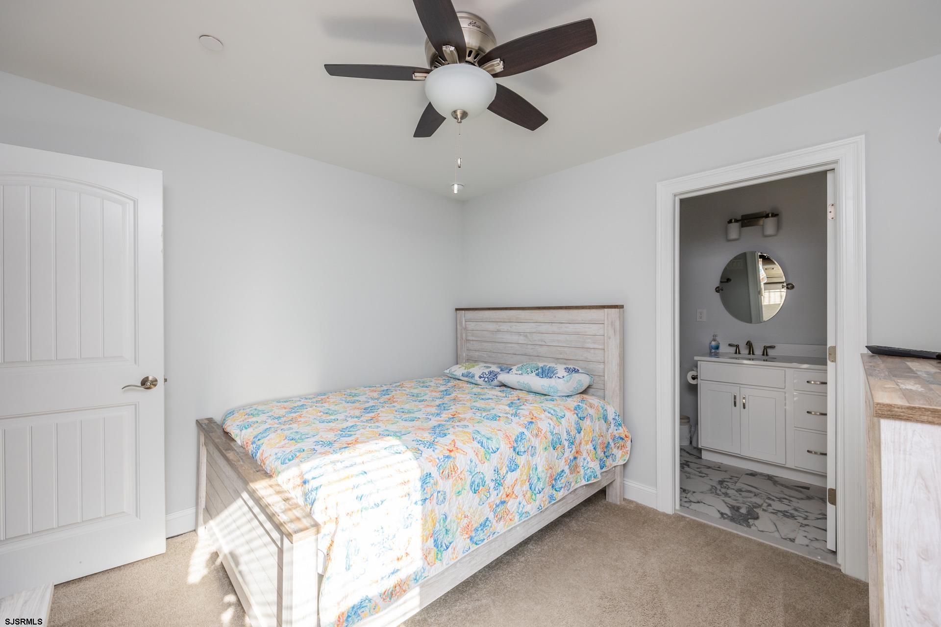 910 Ocean Avenue, Unit C Ocean City, NJ 08226 - Photo 30 of 36 a bedroom with a bed chandelier and dresser