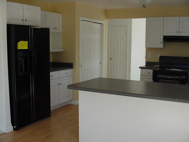1273 East 18th Street Rifle, CO 81650 - Photo 4 of 4 a kitchen with granite countertop a refrigerator and a stove top oven