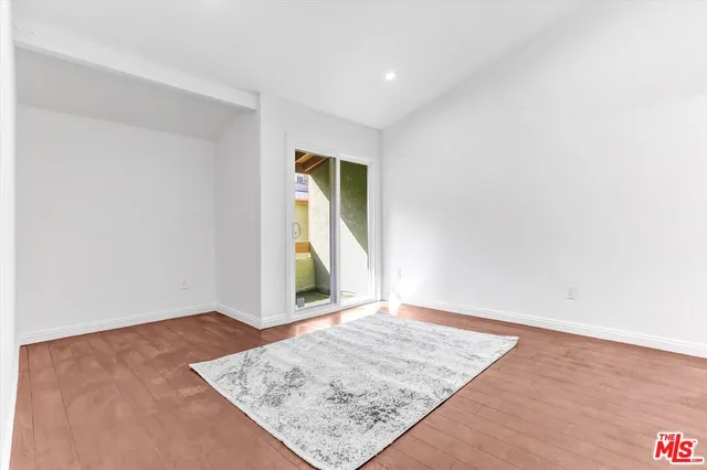 an empty room with wooden floor and a window