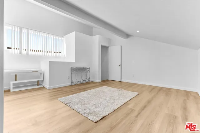 a view of a kitchen with white cabinets and wooden floor
