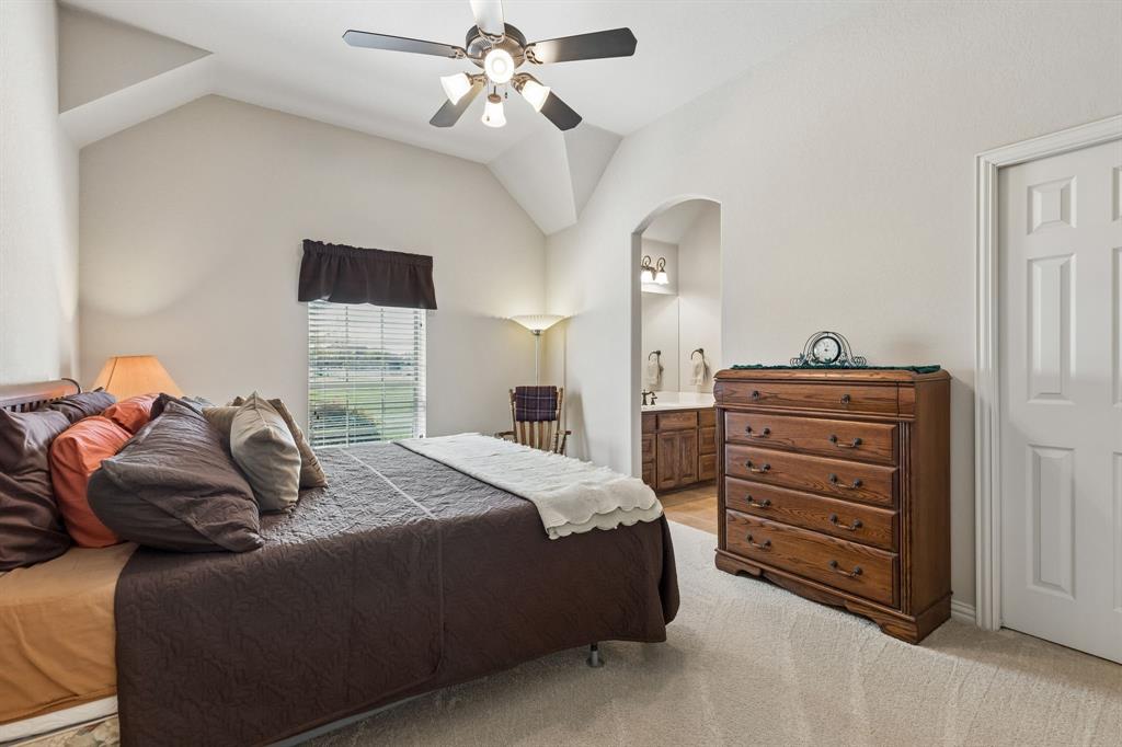 600 Lonesome Trail Haslet, TX 76052 - Photo 27 of 36 a bedroom with a bed and a chandelier